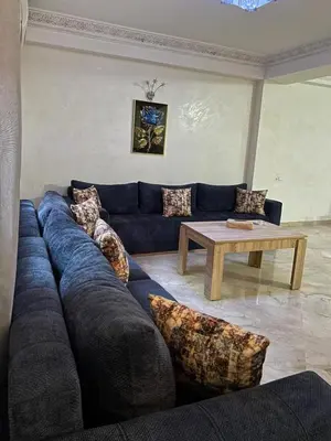 a living room with a blue couch and a table at hébergement in Guéliz in Marrakech