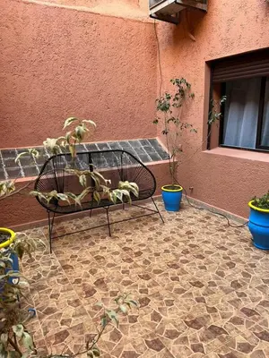 a bench sitting next to a building with potted plants at hébergement in Guéliz in Marrakech