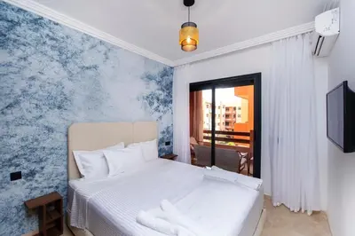 a bedroom with a white bed and blue wallpaper at Modern apartment-pool-secure Gueliz in Marrakech