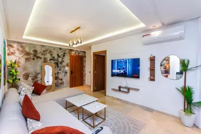 a living room with a white couch and a tv at Modern apartment-pool-secure Gueliz in Marrakech
