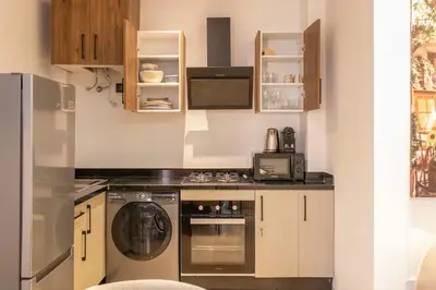 a kitchen with a stove and a refrigerator at Modern apartment-pool-secure Gueliz in Marrakech