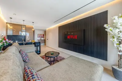 a living room with a couch and a tv on a wall at Luxuriöse Wohnung im Herzen von Marrakesch Gueliz in Marrakech