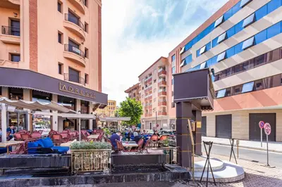 a group of people sitting at tables outside a building at Luxuriöse Wohnung im Herzen von Marrakesch Gueliz in Marrakech