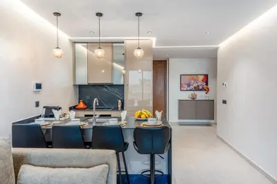 a kitchen and living room with a large dining table at Luxuriöse Wohnung im Herzen von Marrakesch Gueliz in Marrakech