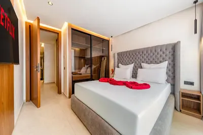 a bedroom with a white bed with red pillows on it at Luxuriöse Wohnung im Herzen von Marrakesch Gueliz in Marrakech