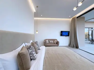 a bedroom with a bed and a couch and a television at Villa de Luxe Sans Vis-à-Vis 15 min de Marrakech in Marrakech