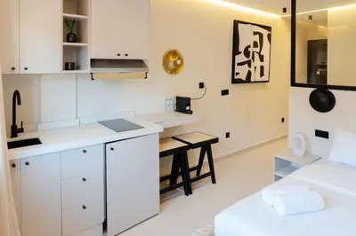 a kitchen with white cabinets and a small table at Studio Chic Coeur de Gueliz in Marrakech