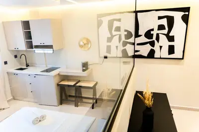 a white kitchen with a counter and a table at Studio Chic Coeur de Gueliz in Marrakech
