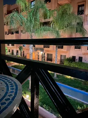 a view from the balcony of a building with palm trees at Vue Fontaine appart in Marrakech