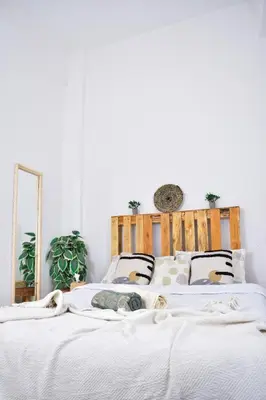 a bedroom with a white bed with a wooden headboard at Quiet apartment of traditional Moroccan in Marrakech