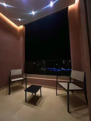a room with two chairs and a large window at Luxury Apartment & Atlas View in Marrakech