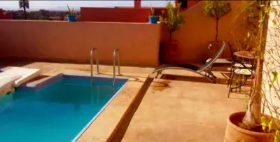 a swimming pool with a chair next to at La Terrasse in Marrakech