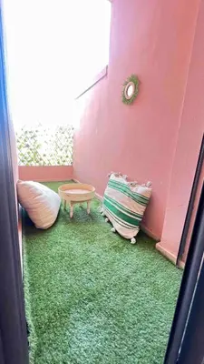 a room with a pink wall and a green carpet at GYM POOL Flat Marrakech Central City in Marrakech