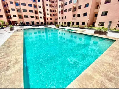 a large blue swimming pool in front of a building at GYM POOL Flat Marrakech Central City in Marrakech