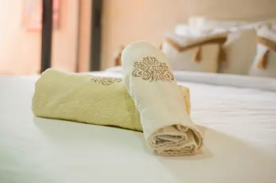 a rolled up towel sitting on top of a bed at GYM POOL Flat Marrakech Central City in Marrakech