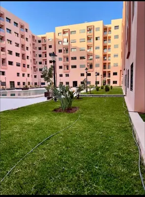 a green lawn in front of a large building at GYM POOL Flat Marrakech Central City in Marrakech