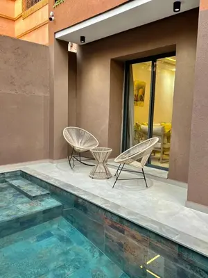 two chairs sitting next to a swimming pool at Villa Privèe avec Piscine Chaufèe à 5min de Gueliz in Marrakech