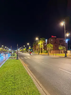 an empty street at night with street lights at Villa Privèe avec Piscine Chaufèe à 5min de Gueliz in Marrakech