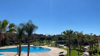 a resort with a pool and palm trees at Dar Saad Atlas golf in Marrakech