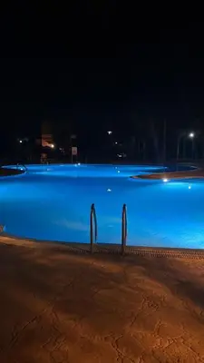 a swimming pool with blue water at night at Dar Saad Atlas golf in Marrakech