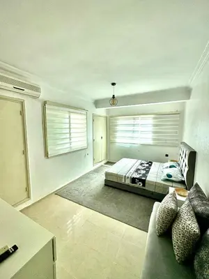 a bedroom with a bed and a couch and two windows at Albaraka building in Marrakech
