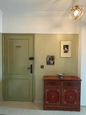 a room with a green door and a wooden cabinet at Albaraka building in Marrakech