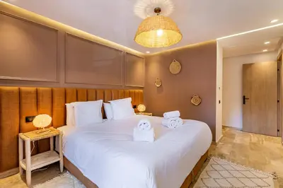 a bedroom with a large white bed with towels on it at La Parenthèse Urbaine - Patio Berbère in Marrakech