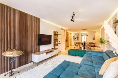 a living room with a blue couch and a tv at La Parenthèse Urbaine - Patio Berbère in Marrakech