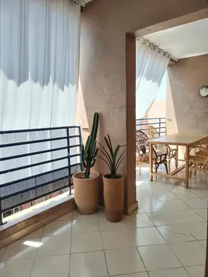 a balcony with two potted plants and a table at White in Marrakech