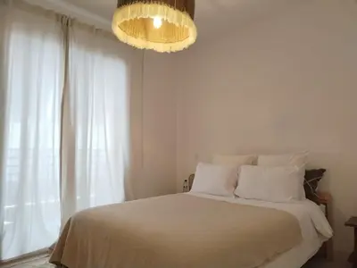 a white bedroom with a bed with a chandelier at White in Marrakech