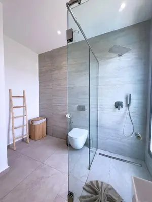 a bathroom with a glass shower with a toilet at Villa Signature - Élégance , Confort en Double in Marrakech