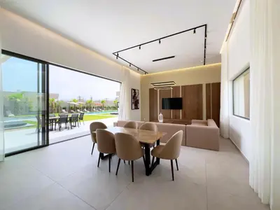 a dining room with a table and chairs and a couch at Villa Signature - Élégance , Confort en Double in Marrakech