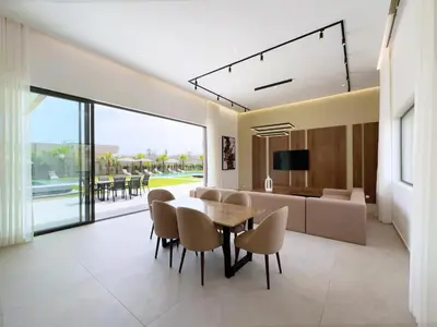 a dining room and living room with a table and chairs at Villa Signature - Élégance , Confort en Double in Marrakech