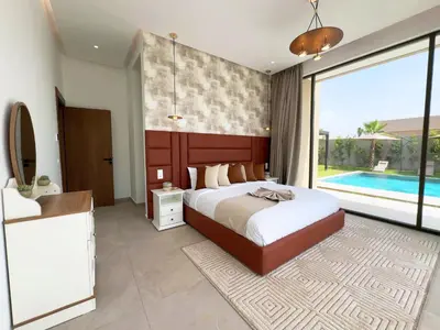 a bedroom with a bed and a bathroom with a pool at Villa Signature - Élégance , Confort en Double in Marrakech