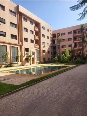 an apartment complex with a swimming pool in front of a building at Duplex Moderne et Confort in Marrakech