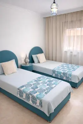 a bedroom with two beds and a window at Duplex Moderne et Confort in Marrakech