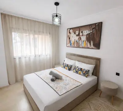 a bedroom with a large white bed and a window at Duplex Moderne et Confort in Marrakech