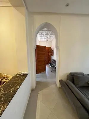 a living room with a couch and a hallway at Villa Benben 6 minutes du Grand Stade de Marrakech in Marrakech