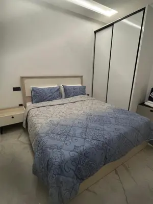 a bedroom with a large bed with blue pillows at Stylish 1 Bedroom Apartment 2 Min to Train and Bus Stations 12 Min to Airport in Marrakech
