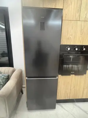 a black refrigerator in a living room with a couch at Stylish 1 Bedroom Apartment 2 Min to Train and Bus Stations 12 Min to Airport in Marrakech