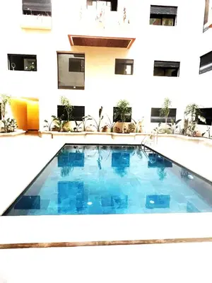 a large swimming pool in front of a building at Stylish 1 Bedroom Apartment 2 Min to Train and Bus Stations 12 Min to Airport in Marrakech