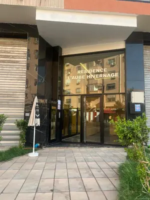 an entrance to a building with an umbrella in front of it at Stylish 1 Bedroom Apartment 2 Min to Train and Bus Stations 12 Min to Airport in Marrakech