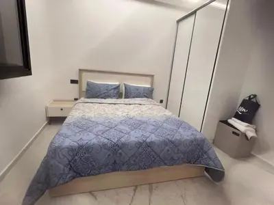 a bedroom with a bed with a blue comforter at Stylish 1 Bedroom Apartment 2 Min to Train and Bus Stations 12 Min to Airport in Marrakech