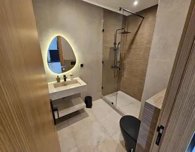 a bathroom with a sink and a shower with a mirror at Appartement cosy hivernage piscine in Marrakech
