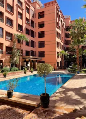 a swimming pool in front of a building at Appartement cosy hivernage piscine in Marrakech