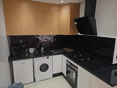 a kitchen with a stove and a washing machine at Appartement cosy hivernage piscine in Marrakech