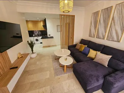 a living room with a purple couch and a table at Appartement cosy hivernage piscine in Marrakech