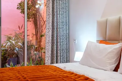 a bedroom with a bed with an orange blanket at 1Br & private garden perfect location in Marrakech in Marrakech