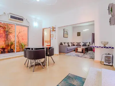 a living room with a table and chairs and a couch at 1Br & private garden perfect location in Marrakech in Marrakech