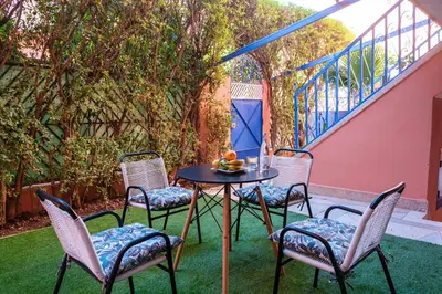 a patio with a table and chairs on the grass at 1Br & private garden perfect location in Marrakech in Marrakech